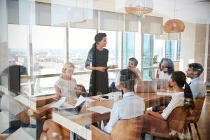 Une femme d'affaires mène une réunion autour d'une table prise à la porte